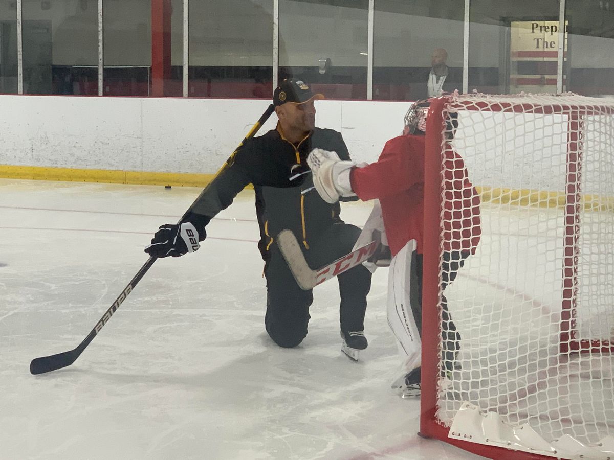 Goaltending coach Andy Chiodo high-fives a goalie during the youth clinic